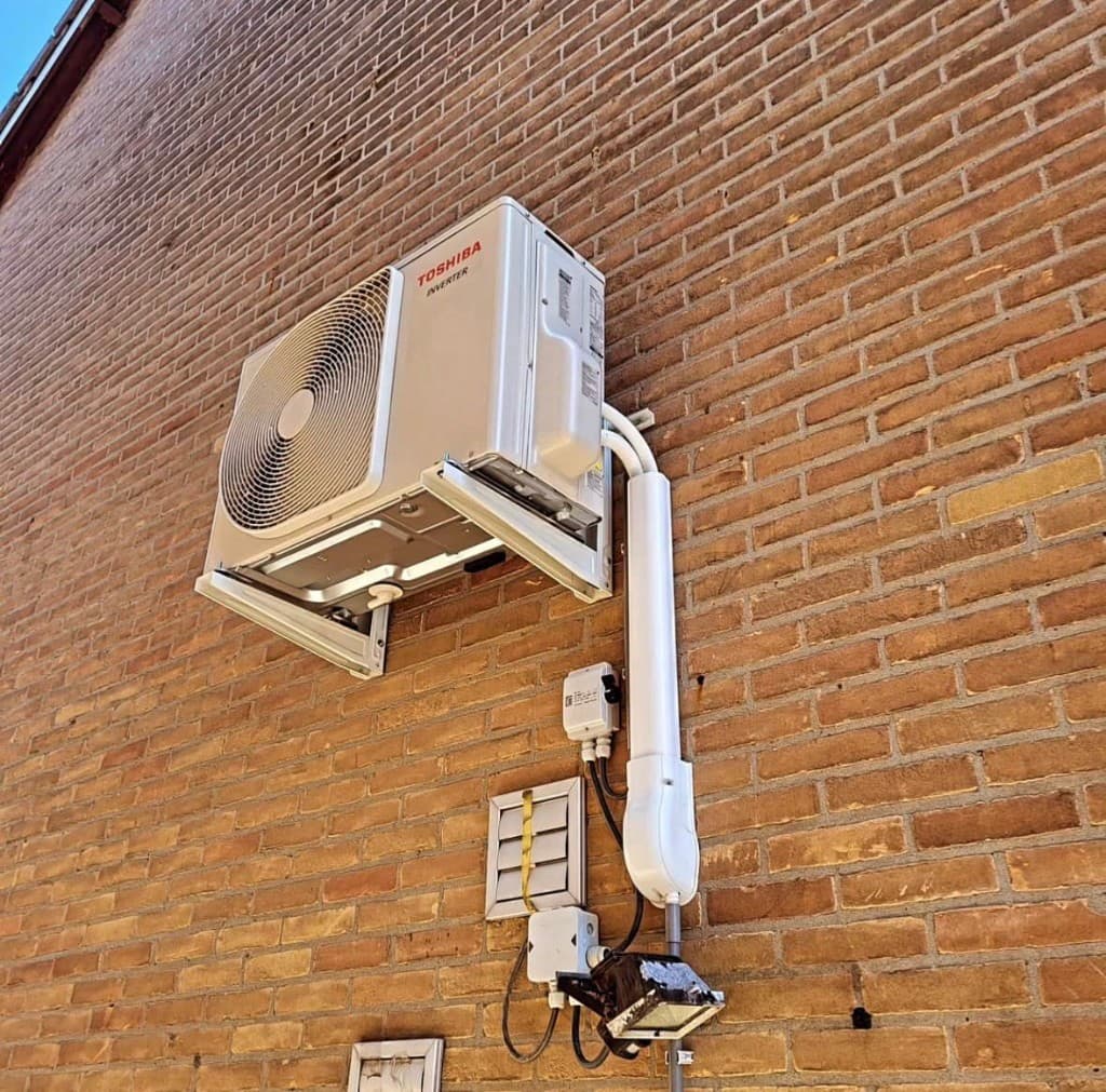 Toshiba Inverter buitenunit met nette leidingvoering aan gevel