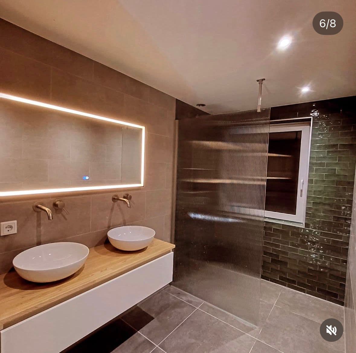 Moderne badkamer met groene douchetegels en LED-spiegel